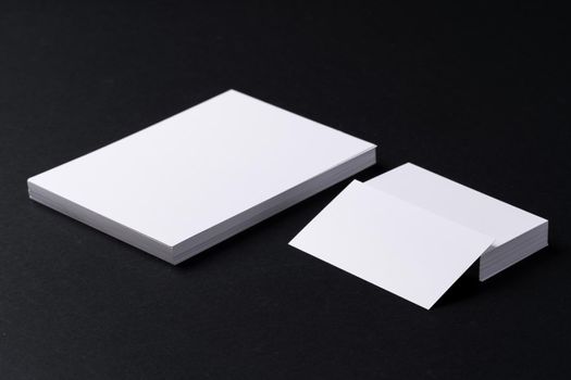 White blank business cards on dark black background, copy space