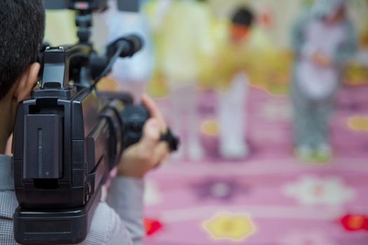 Video camera operator working with his equipment - Image . Video Camera recording kindergarder room with blurred background, copy space - Image .