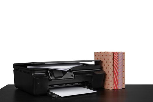 Office table with laser printer and books against white background, close up