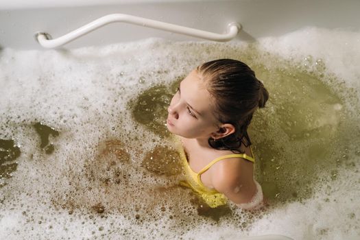 a little girl takes the procedure in a mineral bath. The patient receives water treatments with a mineral pearl bath.