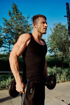 sporty man exercise fitness workout outdoors with dumbbells. High quality photo