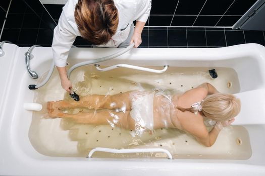 the procedure of underwater shower massage in the bathroom.Girl on the procedure of underwater massage.