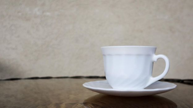 Hot aromatic coffee with milk. Freshly prepared drink is served in a modern cup on a light wicker table