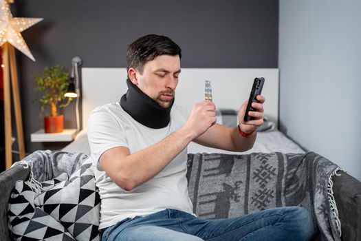 Man after accident in cervical collar consults online video call with doctor and receives recommendations for taking medications. Male in foam cervical spinal injury video conferencing with insurance.
