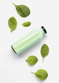 flat lay juice bottle with spinach leaves