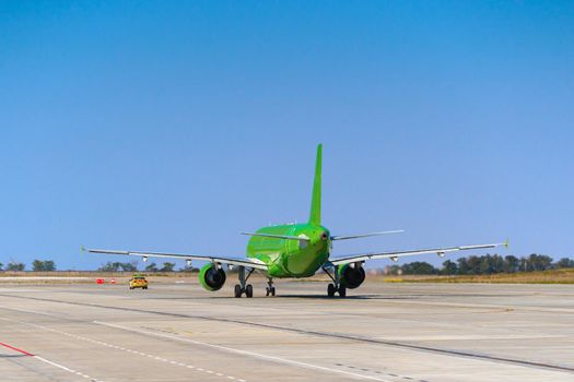 Green passenger airplane at the airport on sunny day photo