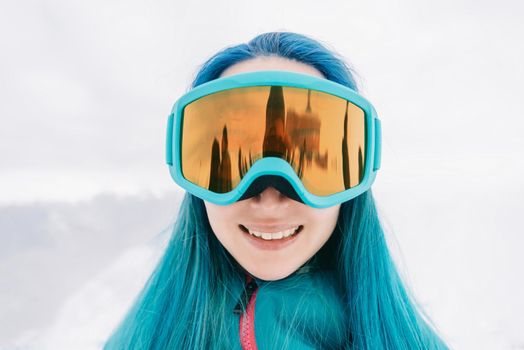 Portrait of smiling sporty young woman wearing in protective sunglasses in winter outdoor.