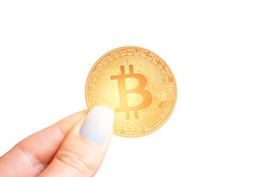 Female hand holding glowing gold bitcoin on a white background, close-up.