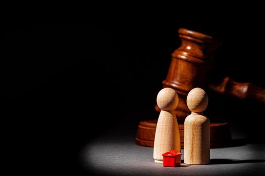 Divorse property division concept. Wooden family with house and judge gavel close up