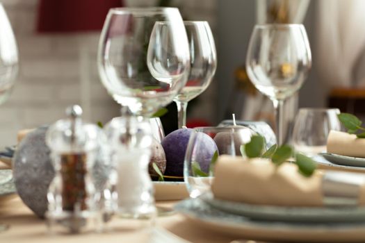 Table setting set with candles and plant branches. Close up.