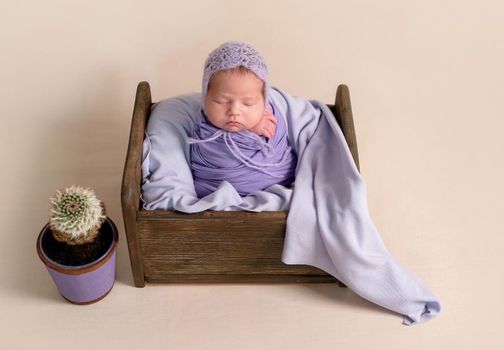 Cute sleeping newborn baby girl in violet