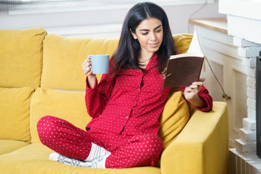 Persian woman at home having tea and reading