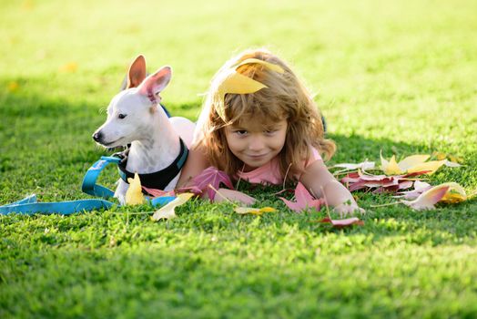 Young child and his dog lying on the grass. Happy boy kid and pet puppy on nature. Happiness support friendship summer animals