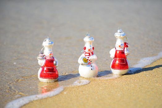 Happy New Year and Christmas. Snow man on sea beach. Xmas travel vacation in hot countries concept