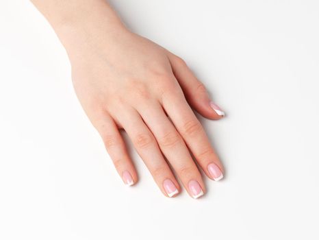 Beautiful female palm with french manicure on white background