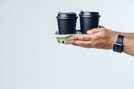 Courier hands giving packed food delivery close up against grey background