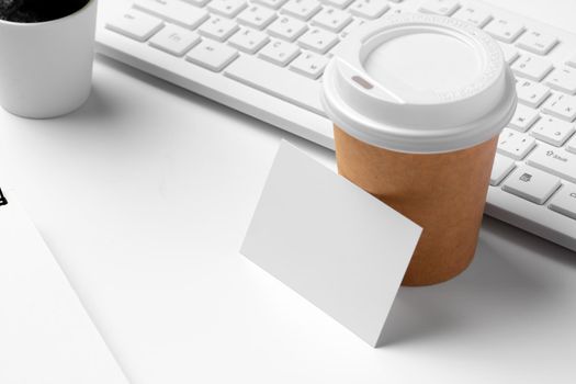 Blank business cards with supplies and keyboard on office table. Close up.