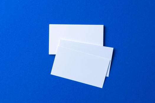 Blank paper business mock up on classic blue background, top view