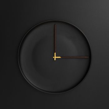 dark plate with chocolate sticks form clock