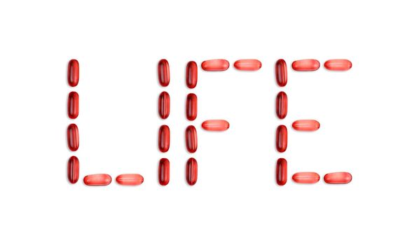 The word Life is laid out with pills. The word Life is laid out with gel pills on a white background with copy space for text.