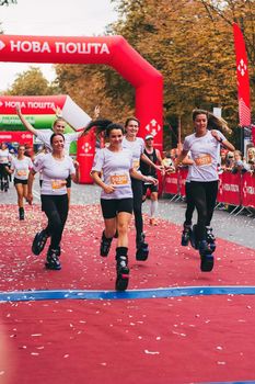 POLTAVA, UKRAINE - 1 SEPTEMBER 2019: A group of sporty women on jumping utilities reach finish line during Nova Poshta Poltava Half Marathon.