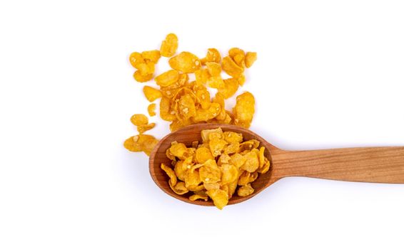 Crunchy corn flakes, cereal, muesli pile in wooden spoon isolated on white background.