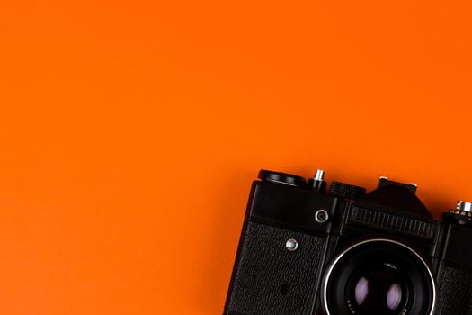 Flat lay film camera isolated on orange background. Copy space