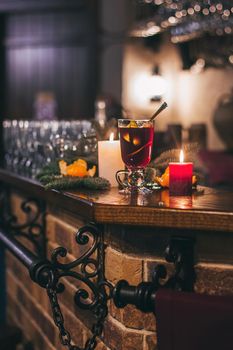 Red hot drink glintwein with spices, cinnamon, anise, fruits, brown sugar on an old wooden table. New Year and Christmas holidays concept. Mulled wine and glintwein