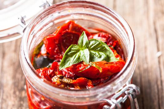 sun dried tomatoes in a glass jar with fresh basil