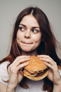 woman with a hamburger in her hands a snack fast food close-up. High quality photo