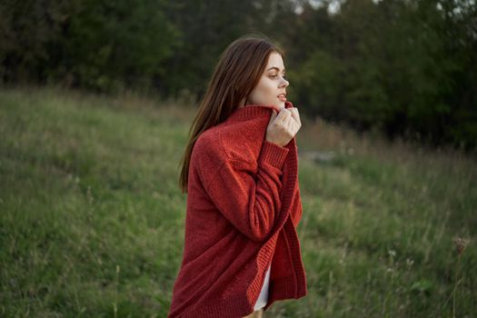 woman outdoors in a red sweater cool nature. High quality photo