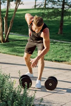 man with dumbbells in the park exercise fitness. High quality photo