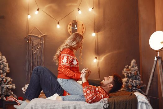 People in a Christman decorations. Man and woman in a red sweater. Family at home.