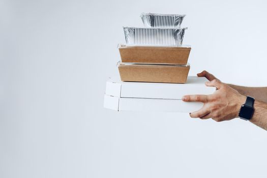 Courier hands giving packed food delivery close up against grey background