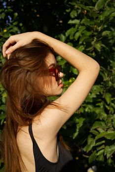 woman in black swimsuit sunglasses nature summer posing. High quality photo