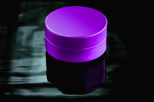 Purple plastic jar in the water on a dark background. Mockup for advertising cosmetics and body care products. Layout of a moisturizer, milk or balm