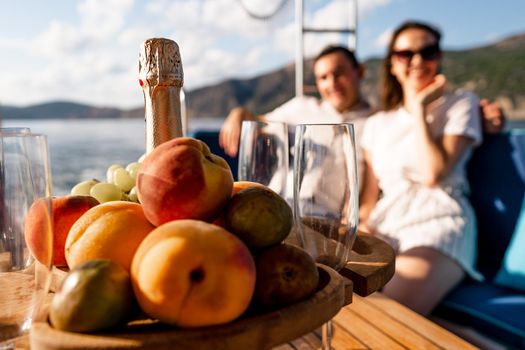 Fruit tray and bottle of champagne for romantic date on a yacht, close up