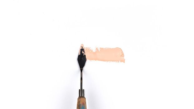 a painting palette knife isolated on a white background painting a pink with copy space.