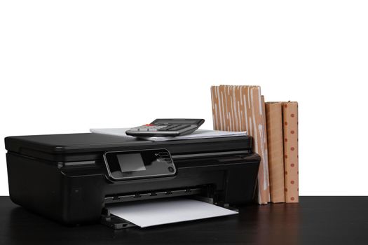 Office table with laser printer and books against white background, close up