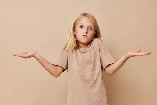 Positive little girl gestures with his hands isolated background. High quality photo