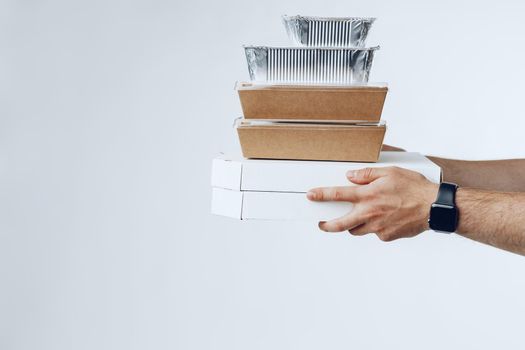 Courier hands giving packed food delivery close up against grey background