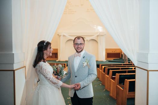 Young bride and groom on their wedding day in a church building.