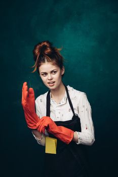 woman with rubber gloves in apron cleaning housework. High quality photo