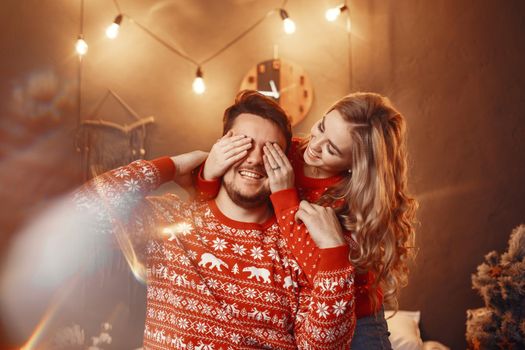 People in a Christman decorations. Man and woman in a red sweater. Family at home.