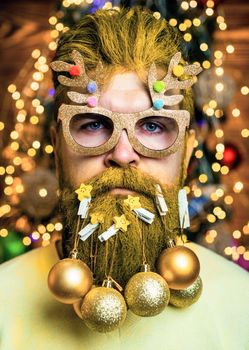 Portrait of a brutal Santa Claus. Beard with bauble. Santa in barber shop. Christmas style for modern Santa. Santa Claus man on Christmas