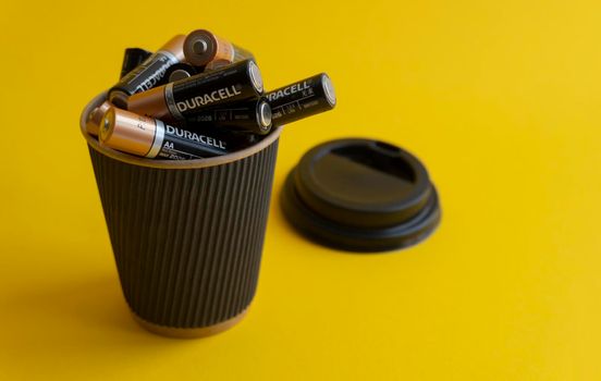 Kiev, Urkaine, 16 June 2020, Closeup at duracell AA alkaline batteries in takeaway coffee cup as association of energy, yellow background, creative idea of using batteries. Copy space.