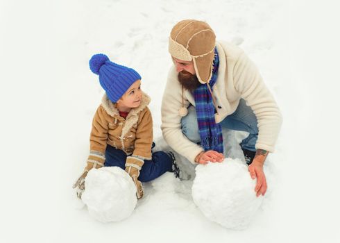 Happy father and son play on winter Christmas time. Father and son making snowball. Thanksgiving day and Christmas. Father and his son playing outdoors