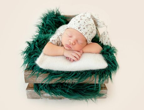 Dreamy newborn baby sleeping peacefully on the side on bed