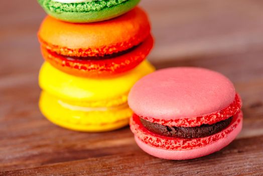 Colorful macarons dessert on a wooden background, closeup.