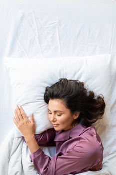 Vertical photo of a beautiful middle-aged woman asleep. Healthy sleep and digital detox concept.